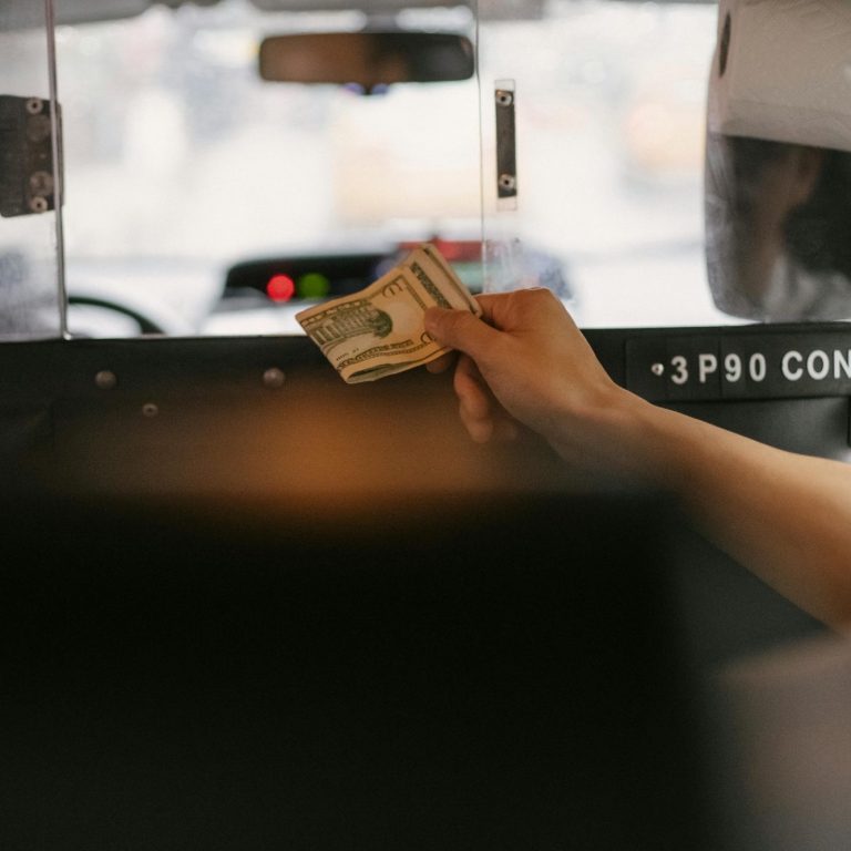 Passenger paying cash for a Houston taxi ride with a local taxi service